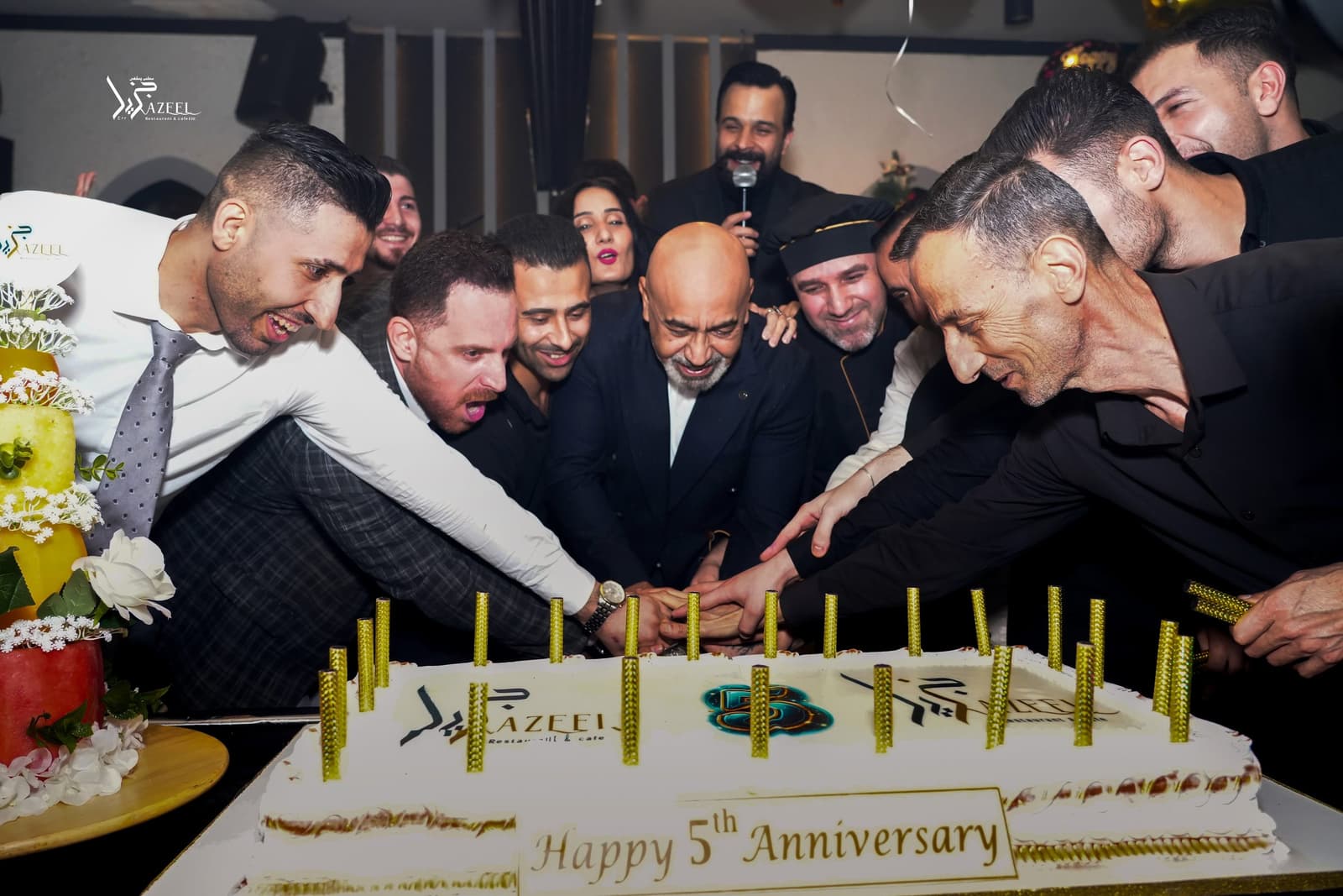 The Jazeel team gathered around an anniversary cake