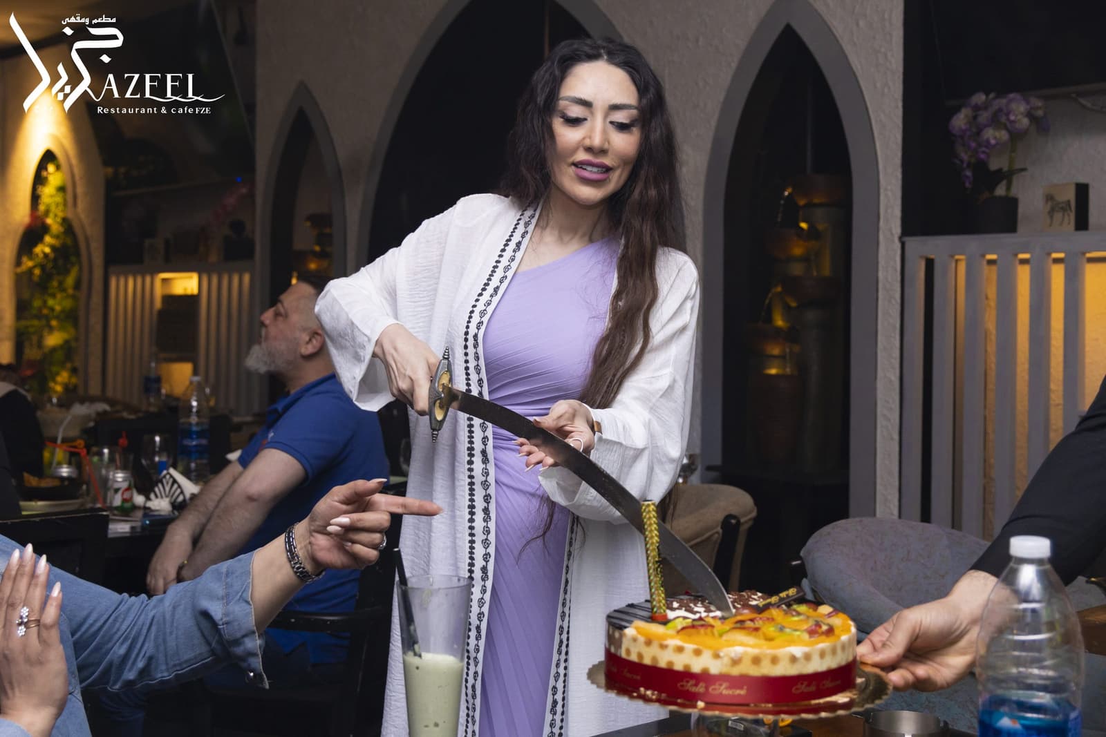 A celebration cake being cut with a ceremonial sword in the dining room