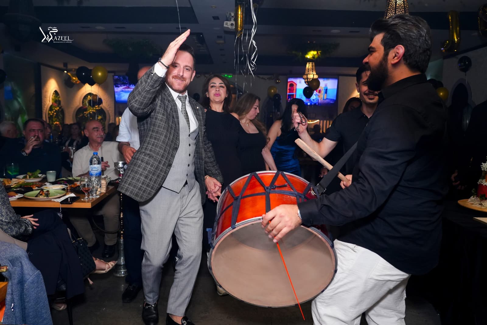 A drummer playing as a guest dances during a celebration