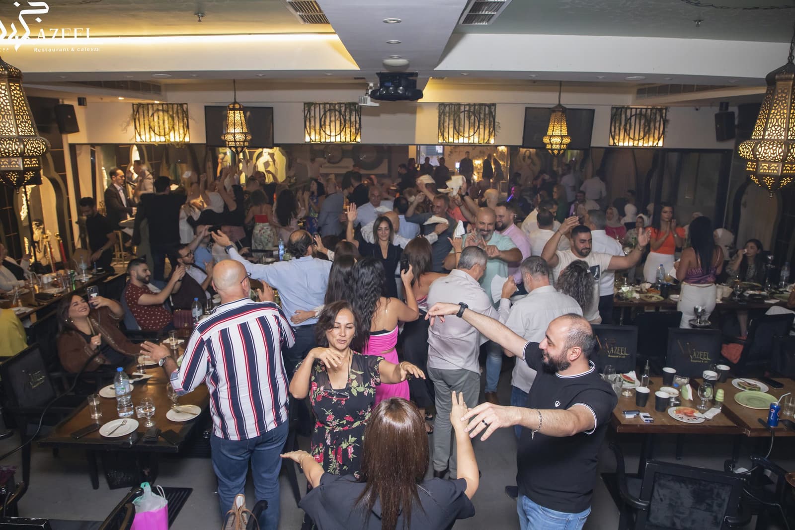Guests up and dancing between the tables during a celebration
