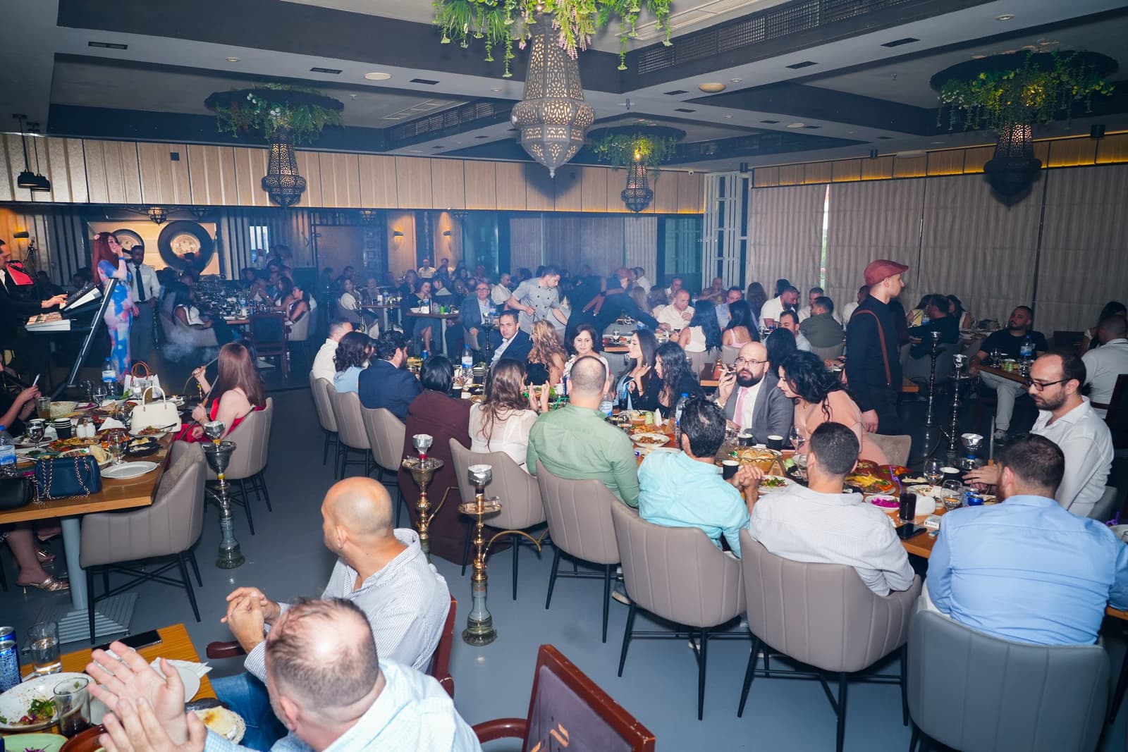 The indoor dining room full for an evening, with a singer on the stage
